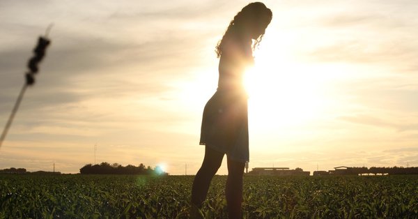 Silhouette of woman walking in field
